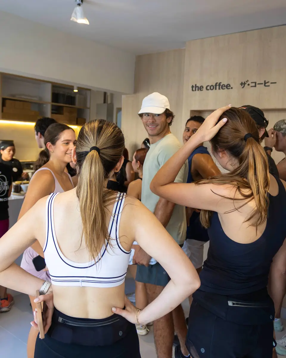 Corredoras y corredores conversan dentro de la cafetería The Coffee al terminar la corrida, todavía con la ropa de entrenar.